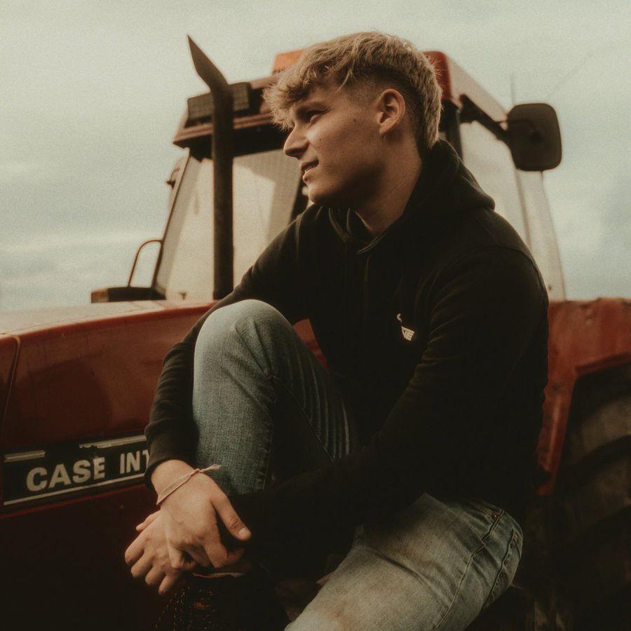 Ben Walker sitting in front of a red tractor